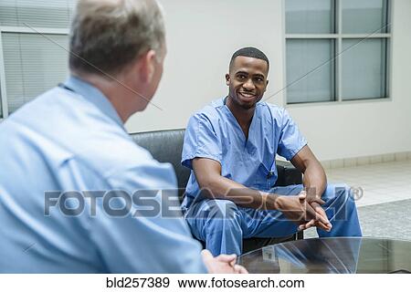 Doctor and nurse talking in lobby View Large Photo Image Stock Photo - Doctor and nurse talking in lobby. Fotosearch
