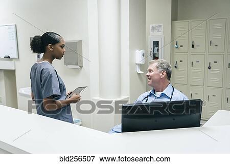 Stock Photo - Doctor and nurse talking. Fotosearch