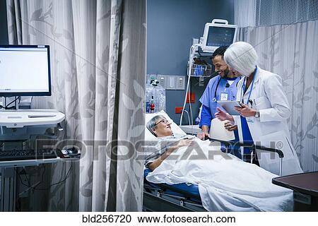 Doctor and nurse talking with patient in hospital bed View Large Photo Image Stock Image - Doctor and nurse talking with patient in hospital bed. Fotosearch