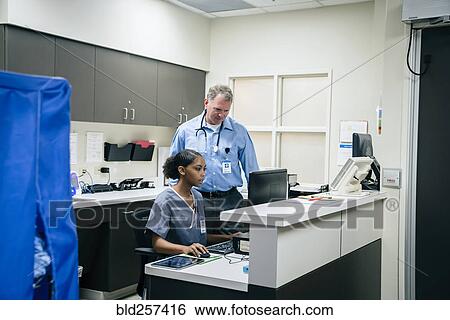 Doctor and nurse using computer in hospital View Large Photo Image Stock Photograph - Doctor and nurse using computer in hospital. Fotosearch