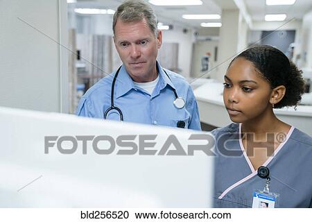 Stock Image - Doctor and nurse using computer. Fotosearch