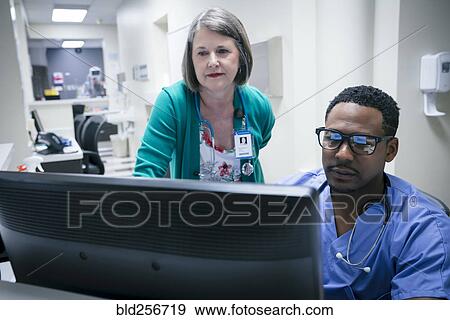 Stock Photo - Doctor and nurse using computer. Fotosearch