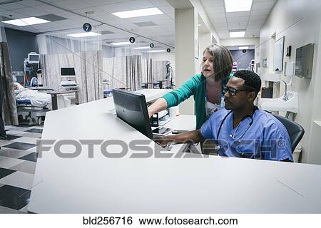 Stock Photograph - Doctor and nurse using computer. Fotosearch
