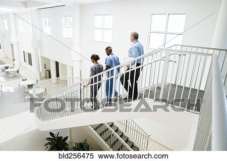 Doctor and nurses descending staircase View Large Photo Image Stock Photography - Doctor and nurses descending staircase. Fotosearch