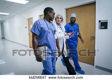 Stock Photo - Doctor and nurses discussing digital tablet in hospital. Fotosearch