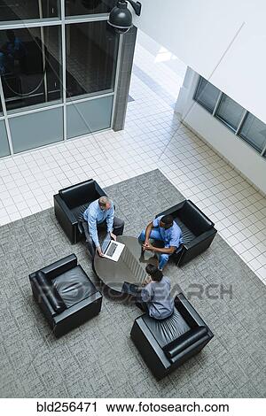 Stock Image - Doctor and nurses discussing laptop. Fotosearch