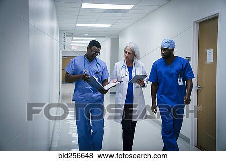 Stock Photo - Doctor and nurses discussing paperwork in hospital. Fotosearch