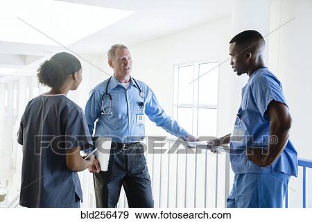 Stock Photo - Doctor and nurses talking. Fotosearch