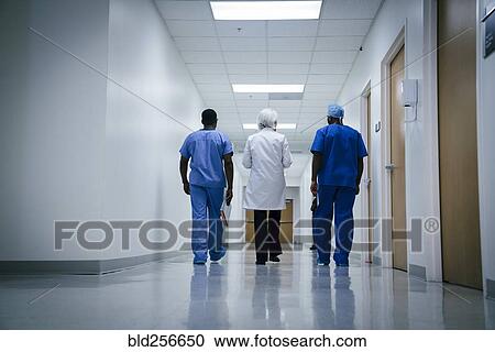 Stock Image - Doctor and nurses walking in hospital. Fotosearch