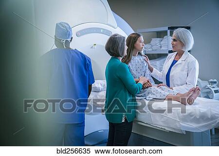 Stock Photography - Doctor comforting patient at scanner. Fotosearch