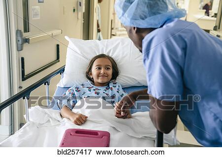 Doctor holding hand of girl in hospital bed View Large Photo Image Stock Photo - Doctor holding hand of girl in hospital bed. Fotosearch