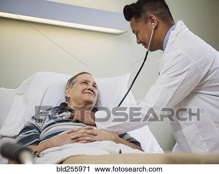Doctor listening to chest of patient with stethoscope View Large Photo Image Stock Image - Doctor listening to chest of patient with stethoscope. Fotosearch