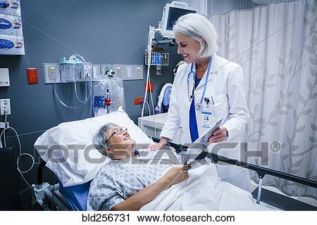 Doctor showing digital tablet to patient View Large Photo Image Stock Image - Doctor showing digital tablet to patient. Fotosearch