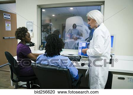 Doctor talking to nurses near scanner View Large Photo Image Stock Image - Doctor talking to nurses near scanner. Fotosearch