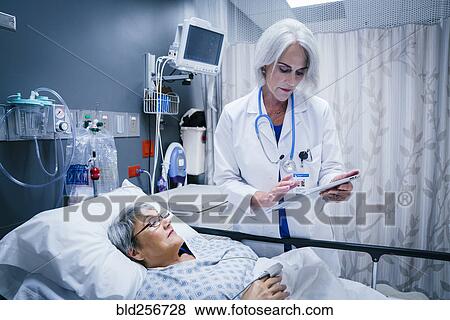 Doctor with digital tablet talking to patient View Large Photo Image Stock Photo - Doctor with digital tablet talking to patient. Fotosearch