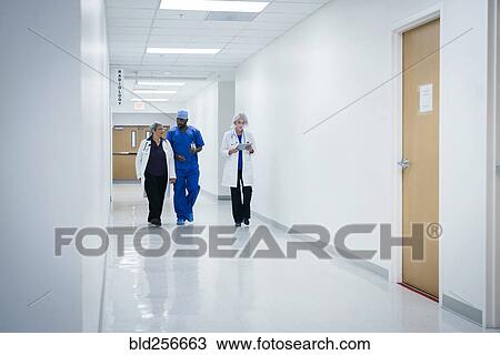 Stock Image - Doctors and nurse walking in hospital. Fotosearch