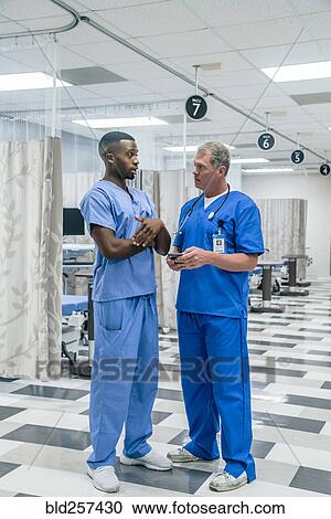 Stock Image - Doctors talking in hospital. Fotosearch