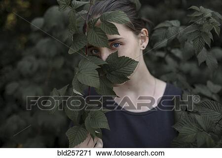 Face of Caucasian teenage girl behind leaves View Large Photo Image Stock Image - Face of Caucasian teenage girl behind leaves. Fotosearch
