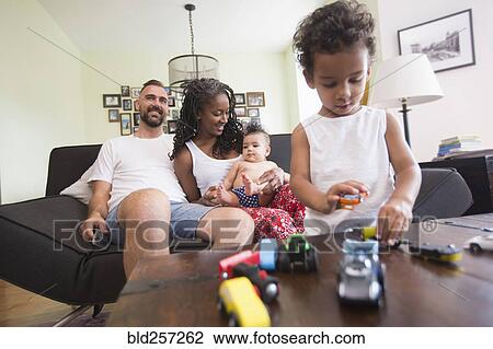 Family relaxing and playing in livingroom View Large Photo Image Stock Image - Family relaxing and playing in livingroom. Fotosearch