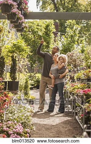 Stock Image - Family shopping at plant nursery. Fotosearch