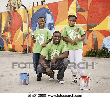 Stock Image - Father and children volunteering together. Fotosearch