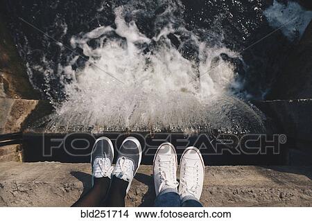 Feet of people standing at the edge of flowing water View Large Photo Image Picture - Feet of people standing at the edge of flowing water. Fotosearch