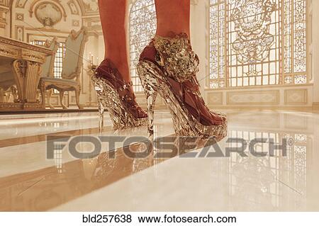 Stock Photo - Feet of woman wearing clear high heel shoes. Fotosearch