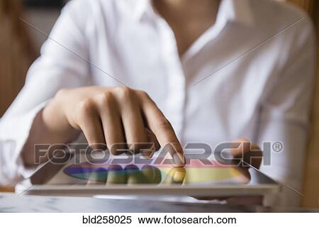 Stock Photography - Finger of African American woman using digital tablet. Fotosearch
