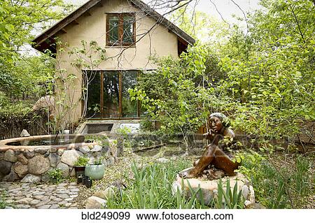 Stock Photo - Fountain and statue in garden near house. Fotosearch