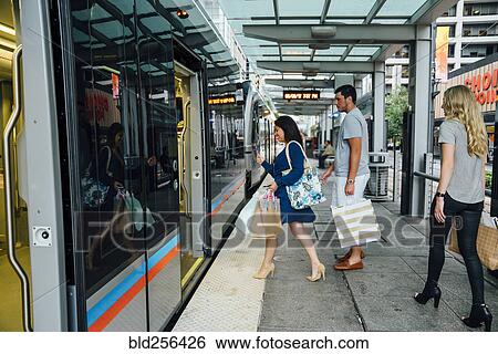 Friends boarding train carrying shopping bags View Large Photo Image Stock Photograph - Friends boarding train carrying shopping bags. Fotosearch