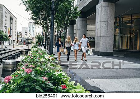 Friends carrying shopping bags in city View Large Photo Image Stock Image - Friends carrying shopping bags in city. Fotosearch