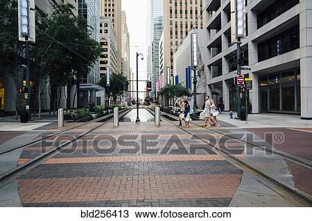 Stock Image - Friends crossing street in city. Fotosearch
