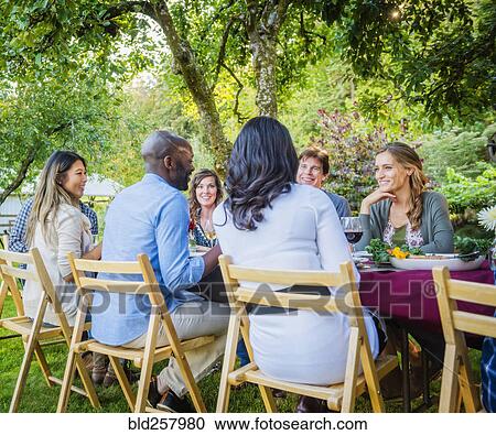 Friends enjoying wine at party outdoors View Large Photo Image Stock Image - Friends enjoying wine at party outdoors. Fotosearch