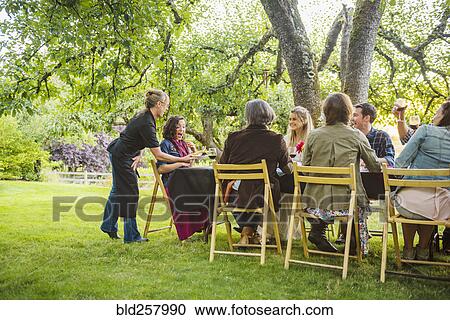 Friends enjoying wine at party outdoors View Large Photo Image Stock Image - Friends enjoying wine at party outdoors. Fotosearch
