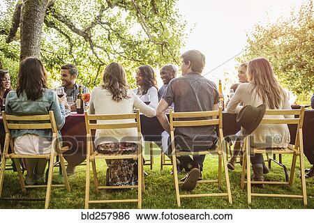 Friends enjoying wine at party outdoors View Large Photo Image Stock Photograph - Friends enjoying wine at party outdoors. Fotosearch