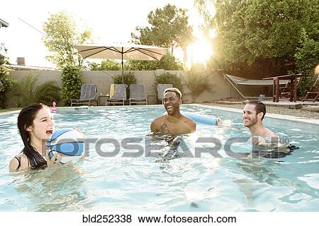 Stock Photo - Friends playing basketball in swimming pool. Fotosearch