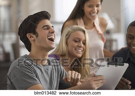 Friends sharing a digital tablet View Large Photo Image Stock Image - Friends sharing a digital tablet. Fotosearch