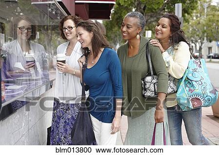 Stock Image - Friends shopping together in city. Fotosearch