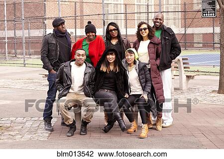 Stock Image - Friends sitting on bench together. Fotosearch