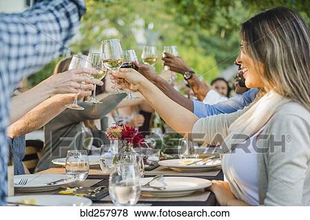Friends toasting with wine at party outdoors View Large Photo Image Stock Photo - Friends toasting with wine at party outdoors. Fotosearch