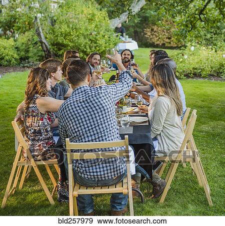 Friends toasting with wine at party outdoors View Large Photo Image Stock Photo - Friends toasting with wine at party outdoors. Fotosearch
