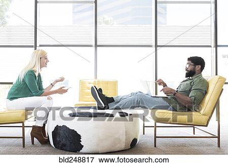 Friends using technology in lounge View Large Photo Image Stock Photo - Friends using technology in lounge. Fotosearch