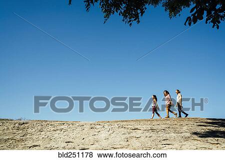 Friends walking under blue sky View Large Photo Image Stock Photo - Friends walking under blue sky. Fotosearch