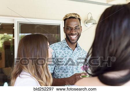 Stock Photo - Friends with cold drinks laughing outdoors. Fotosearch