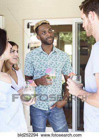 Friends with cold drinks talking outdoors View Large Photo Image Picture - Friends with cold drinks talking outdoors. Fotosearch