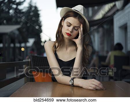 Stock Photo - Frustrated Caucasian woman at sidewalk cafe. Fotosearch