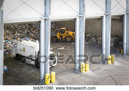 Stock Image - Garbage truck unloading trash. Fotosearch