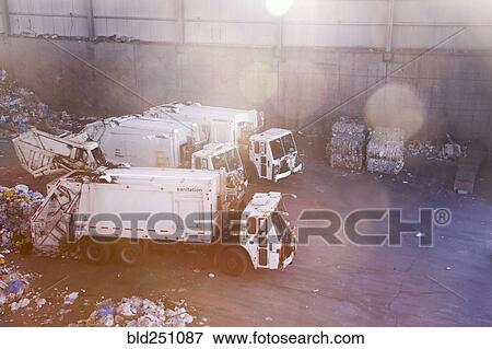 Stock Photo - Garbage trucks unloading trash. Fotosearch