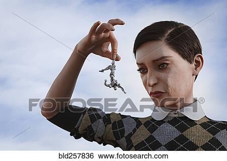 Stock Photograph - Giant woman holding robot upside-down by leg. Fotosearch