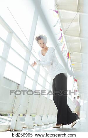 Stock Photography - Glamorous Caucasian woman leaning on railing. Fotosearch